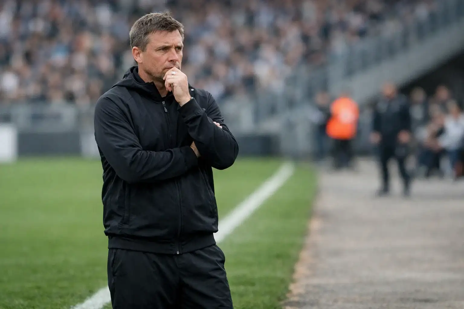 Trainer am Spielfeldrand beobachtet konzentriert das Spielgeschehen